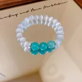 Macro detail of turquoise and white cat-eye beaded bracelet with zirconia spacers - Bracelet-Green-Transparent