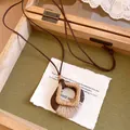 Detail van een Boheemse retro ketting met houten en touw hanger aan een bruin koord. - Houten Ruit Stijl (Koffie-Ruit)
