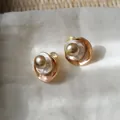 Detailopname van vintage Maillard-stijl goudkleurige pareloorbellen met emaille finish - Oorclips / Goudbruin