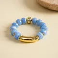 Detailansicht der blauen Acrylperlen und Goldakzente auf einem elastischen Armband - Elastischer Runder Perlenstil / Blau