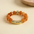 Bernsteinfarbenes elastisches Acryl-Perlenarmband mit polierten Goldelementen - Elastischer Runder Perlenstil / Kaffeebraun