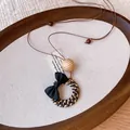 Detailed view of a bohemian woven pendant necklace with a black bow and tiger eye beads. - Bow Woven Ring Style (5#)
