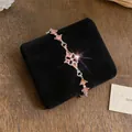 Detailweergave van een elegant roze strass-armband op luxe zwart fluweel - Zilver-Roze