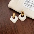 Detailopname van stijlvolle goudgehamerde en witte hars geometrische oorknopjes. - Gehamerde Geometrische Stijl (4#) / Goud+Wit