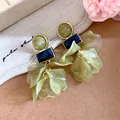 Macro view of olive green acrylic petal earrings with navy rectangular accents - Green
