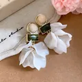 Close-up of elegant acrylic flower petal earrings with geometric resin accents. - White