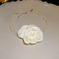Nahaufnahme einer eleganten weißen Stoffblume und einer mehrlagigen Perlenkette auf einem Teller. - Halskette-Weiße Perle / Blassgelbe Blume