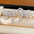 Detaillierte Makroansicht eleganter silberner Schleifen-Ohrclips mit weißen Zirkonia - Ohrclips / Silber