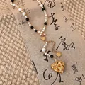 Vintage-Perlenkette mit goldenem Herzanhänger, schwarzen Perlen und feinen Details - Gold