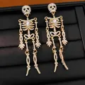Detailaufnahme von vergoldeten Skelett-Ohrringen mit funkelnden Strasssteinen und Kristallen. - Totenkopf Quaste Stil / Gold AB-Farbe