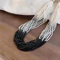 Makroansicht einer mehrsträngigen Glasperlenkette in Schwarz, Grau und Weiß. - Mehrlagig Perlen / Weiß-Grau-Schwarz