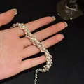 Gedetailleerd zicht op een elegante Franse stijl zirkoon en parel armband op de hand - Golf Geometrische Parelstijl (HB4329)