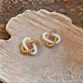 Vue détaillée de boucles d'oreilles géométriques vintage dorées et blanches entrelacées - Style Torsadé Ajouré (HE35515) / Or+Blanc