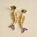 Détail de boucles d'oreilles squelette de poisson dorées avec émail violet et perles - Or-Vert-Violet