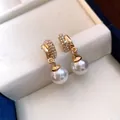 Detailed view of elegant gold-plated stud earrings featuring crystals and pearls - Double Layer Rhinestone Round Style (HE35510) / Gold with White