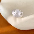 Detailopname van een geborstelde zilveren ovale ring met steruitsneden en zirkoon - Ring - Zilver