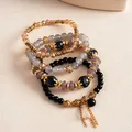 Detalle de un juego de 4 pulseras étnicas vintage de cuentas con borlas doradas y cristales - Set de 4 piezas / Negro
