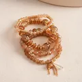 Primer plano de un conjunto de 4 pulseras vintage con cuentas de acrílico ámbar y vidrio. - Set de 4 piezas / Café Claro