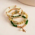 Detalle de pulseras de cuentas retro étnicas con acrílico veteado y detalles dorados - Set de 4 piezas / Verde