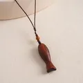 Close-up macro detail of a vintage wooden fish pendant necklace with brown hand-woven cord - Oval Fish Style / Brown