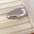 Detailed close-up showing the mirror finish of a minimalist silver oval metallic stud earring - Ring (HR3986) / Silver