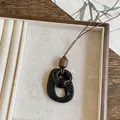 Primer plano detallado de un collar con colgante ovalado de resina retro y rugoso - Estilo de Elipse Texturizada a Mano