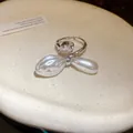 Makroansicht eines silbernen offenen Rings mit Birnenzirkon und zwei Barockperlen - Silber