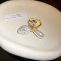 Detailansicht eines vergoldeten offenen Rings mit Wassertropfen-Zirkon und Barockperlen - Gold