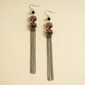 Détail de boucles d'oreilles vintage en acrylique avec imprimé bambou et longs glands - Crochets d'oreilles à pompons / Brown and Black