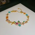 Macro detail of luxury 18k gold plated bracelet featuring vibrant colorful zircon flower motifs - Bracelet / Gold-Multicolor