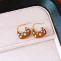 Gros plan de boucles d'oreilles créoles à pois en émail marron plaqué or 18 carats - Brun doré
