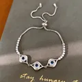 Vue détaillée du bracelet œil protecteur avec des zircons et pierres bleues. - Style Triple Oeil (HB7020)