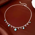 Detailed silver necklace with turquoise beads and clear zircons on brown satin background - Scalloped Pendant Necklace (HN13449) / Silver & Blue