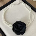 Detailansicht einer mehrlagigen Perlenkette mit großem schwarzem Stoffrosen-Anhänger. - Halskette-Weiße Perle / Schwarze Blume