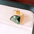 Detailansicht eines goldfarbenen Vintage-Rings mit großem grünem dreieckigem Edelstein - Gold Grün
