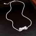 Détails d'un élégant collier à nœud en argent avec zircons et accents de perles fines - Argent