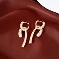 Detailed macro view of 18k gold plated CZ double layer pendant luxury earrings on red silk. - Ear Buckle - Gold - Genuine Gold Plated