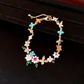 Close-up of 18k gold-plated bracelet featuring colorful zircon flowers and butterflies - Bracelet / Gold-Multicolor