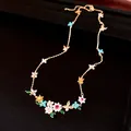 Close-up of 18k gold plated necklace with colorful zirconia flowers and butterflies - Necklace / Gold-Multicolor