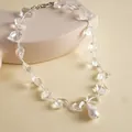 Close-up of a minimalist necklace featuring clear glass beads and a white pearl pendant - Silver White
