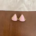 Primer plano de elegantes pendientes de triángulo en esmalte rosa con bordes dorados - Triángulo Dorado / Rosa
