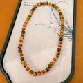 Primer plano de una pulsera de cuentas de ojo de tigre y vidrio estilo Maillard en bandeja - 1# Pulsera