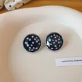 Detailopname van vintage ronde oorknopjes met zwart-witte polkadots - Zwart