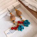 Detailaufnahme von Ethno-Ohrringen mit Holzperlen und blauem Blumendesign - L / Kaffee Rot Blau