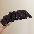 Gedetailleerd overzicht van een bruine geplooide bananenhaarklem met blauwe stippen - Twist Clip / Koffie Stippen