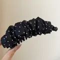 Detailweergave van een vintage zwarte bananenklem met witte stippen en plooistof - Twist Clip / Zwart - Stippen
