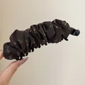 Gedetailleerd aanzicht van een vintage bruine banaan haarklem met bloemenpatroon - Twist Clip / Bruin-Bloemen