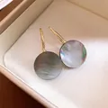 Elegante goldfarbene Hakenohrringe mit irisierenden runden dunklen Muschelanhängern in Geschenkbox - Round Shell Pendant Hook Earrings (HE35528) / 925 Silberstecker / Gold-Weiß