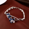 Macro view of an elegant gold plated silver bracelet featuring blue zircon flower petals. - Bracelet / Silver & Blue