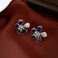Close-up view of elegant flower stud earrings with blue pear-cut zirconia petals - Stud Earrings (Silver Pin) / Silver & Blue